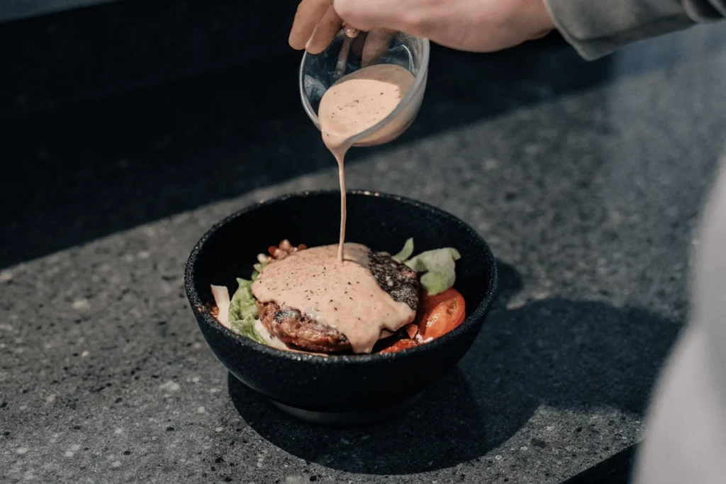 Drizzling Sauce on Burger Bowl