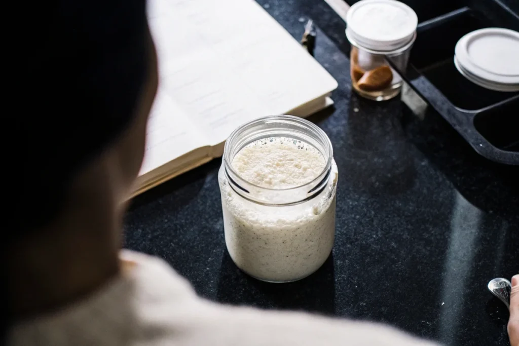 A healthy and active sourdough starter with baking supplies.