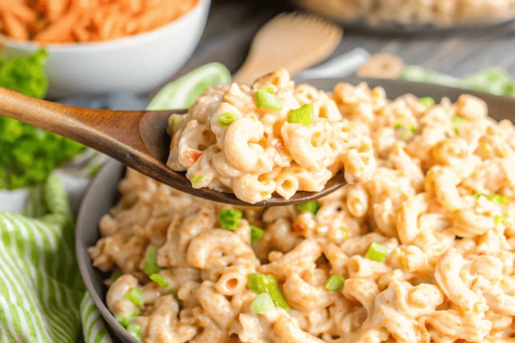 Close-up of creamy Hawaiian Macaroni Salad on a wooden spoon.